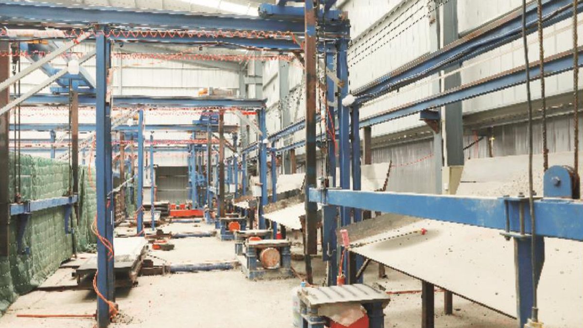 Concrete slat production line inside a KeMuHua plant bay, with demoulding gantry and mould pallets